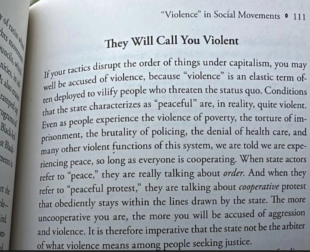A photograph of an open book showing a page titled “They Will Call You Violent” from the chapter “Violence in Social Movements” in Let This Radicalize You by Kelly Hayes and Mariame Kaba. The passage argues that tactics disrupting capitalist order are often labeled as 