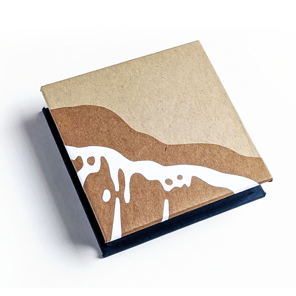 reverse cover of the accordion book depicting wet sand and foam using kraft paper