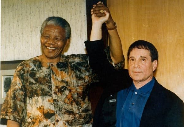Nelson Mandela stands with Paul Simon.