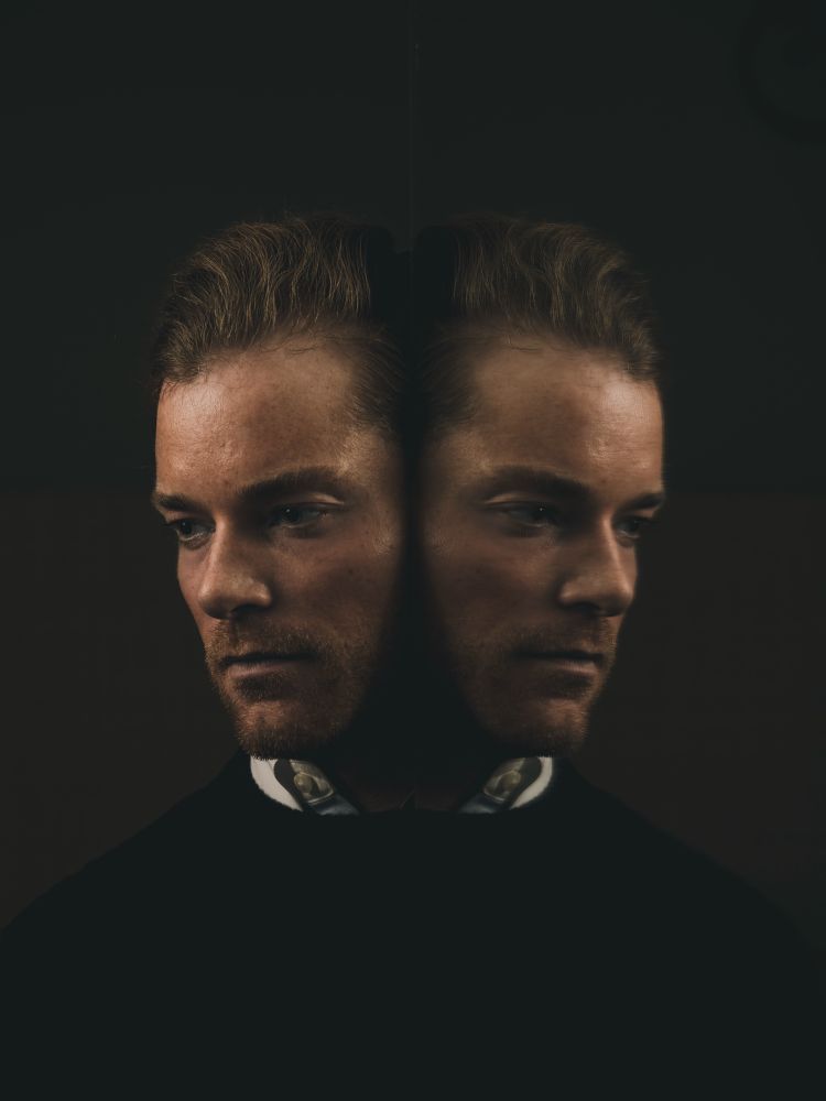 Man reflected in mirror in dark and moody lighting