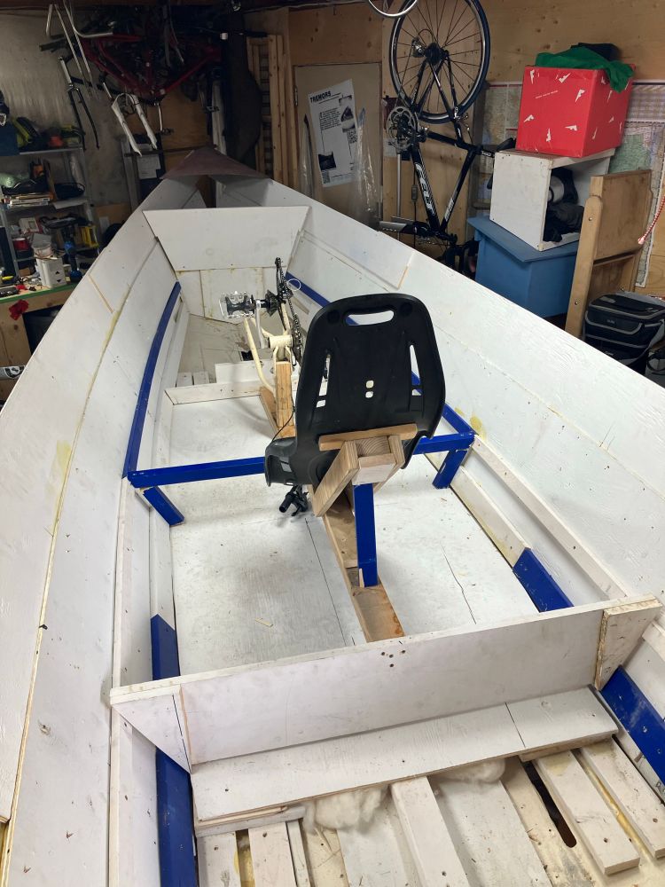 the cockpit of a pedal powered boat in construction showing rough laid planks, enlargened ribs, a recumbent captains seat, pedal armiture.. with a view towards the bow. the lines of planking are starting to look clean and purposeful even if 'the boatshed' is cluttered with two- wheel carcasses and injured rides.

looking forward, with anticipation, to the next sojourn to Calgary for another bout of hammer and nails, screwgun and epoxy!