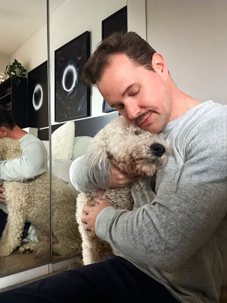 Sitting on floor hugging my sheepadoodle 