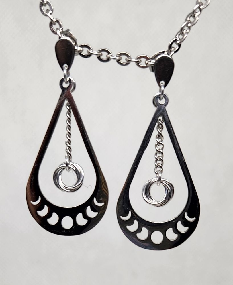 Teardrop shaped silver earrings with mobius units dangling from chains in the middle of each.