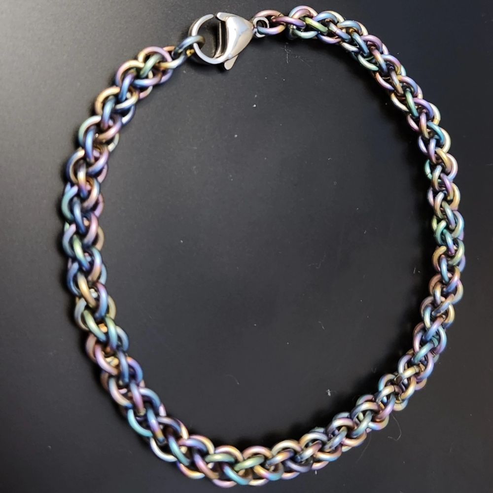 Rainbow chainmail bracelet against a black background