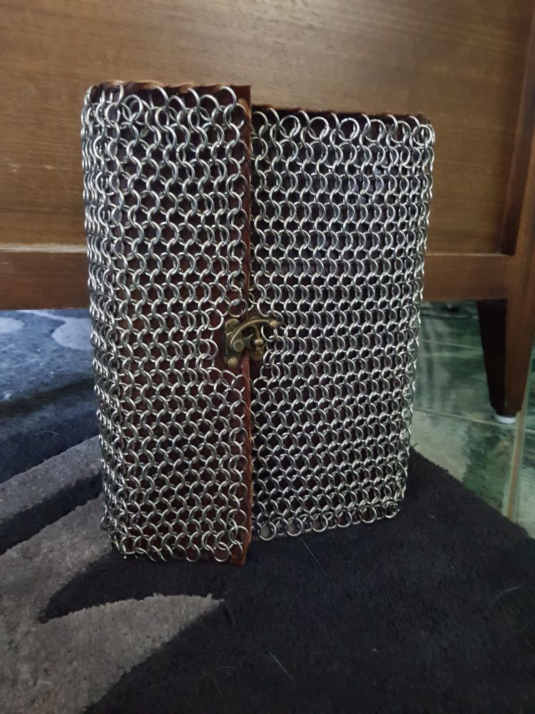A leather book covered in stainless steel chainmail