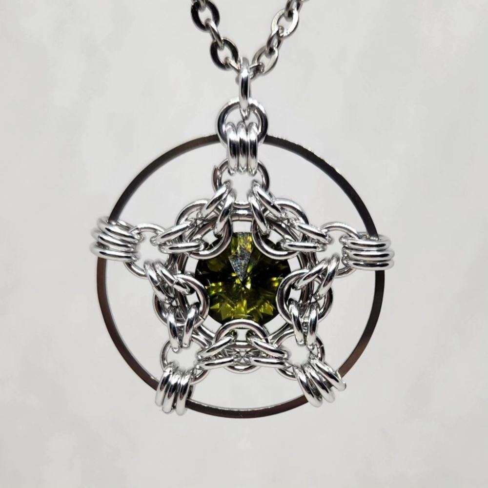 A star shaped pendant with a deep green stone at the centre