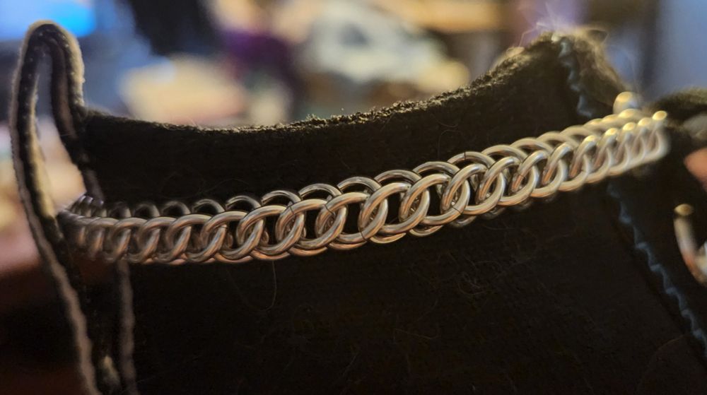 Silver aluminium chainmail chain on a black shoe