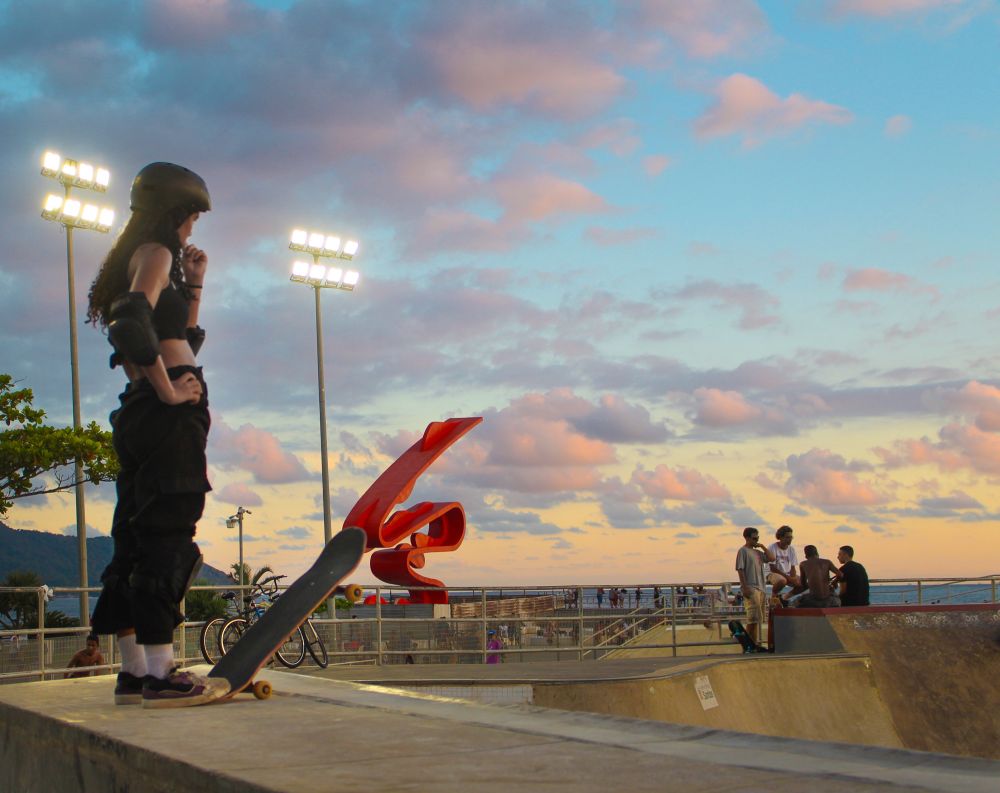 Girl about to drop on vert ramp tomie othake monument on the background on sunset