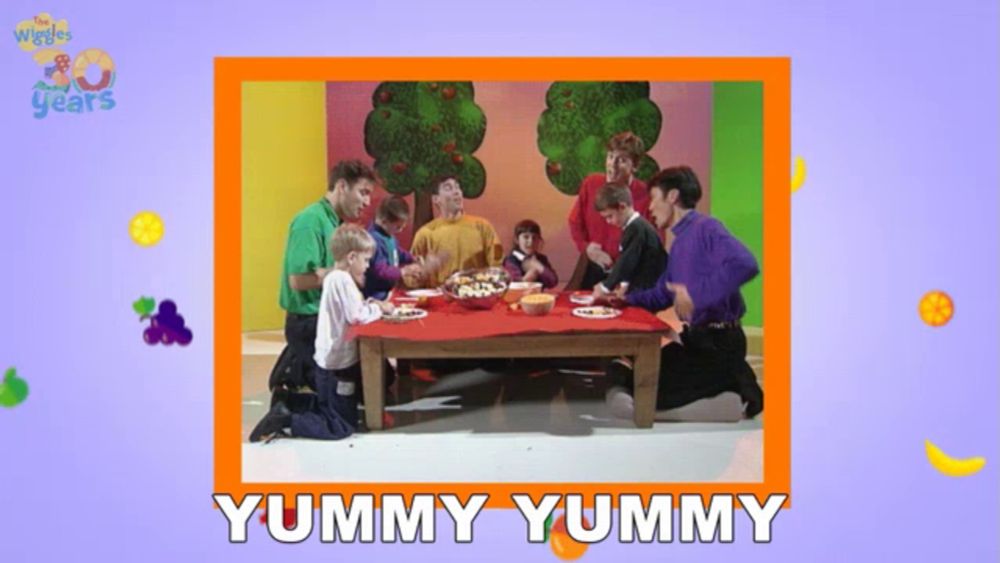 a picture of a group of people sitting around a table with the words yummy yummy on the bottom