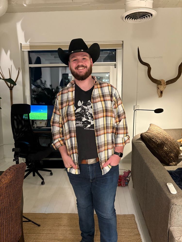 Me wearing a flannel and black cowboy hat 