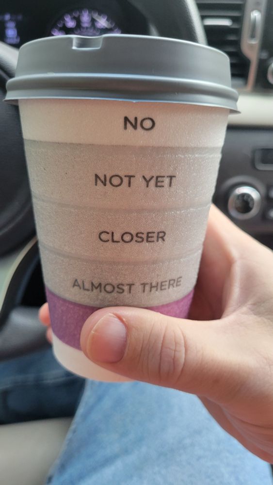 Travel coffee mug that says NO NOT YET CLOSER ALMOST THERE
