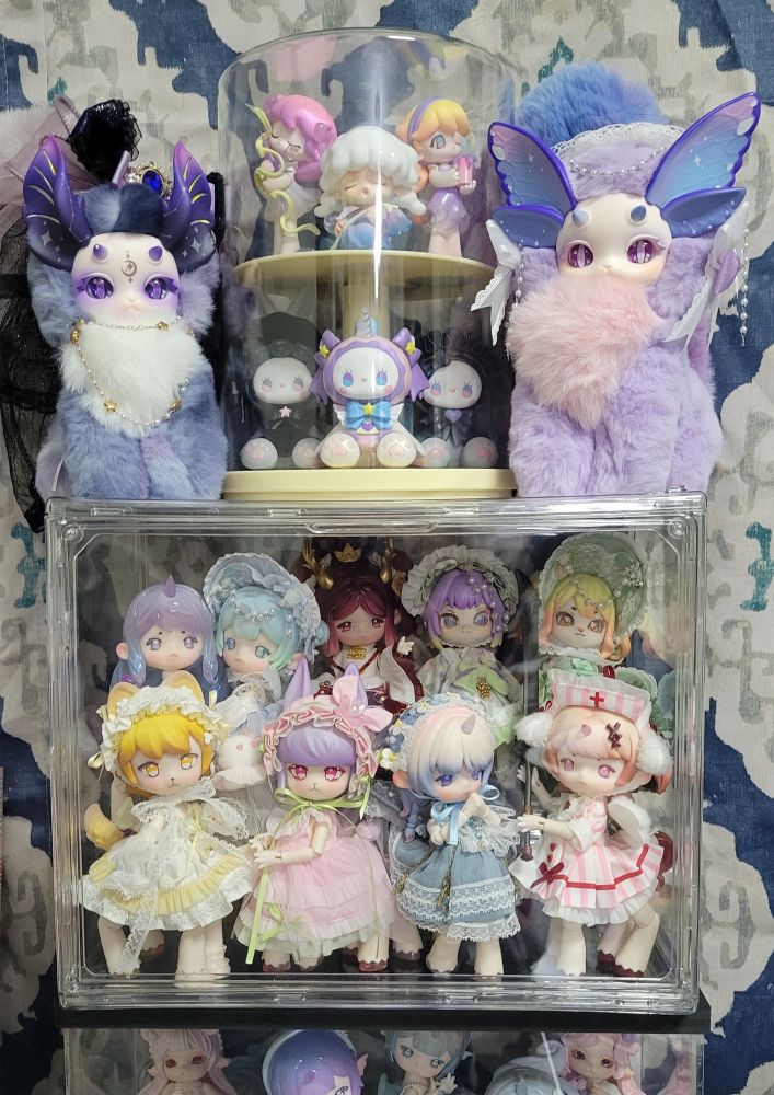 a closeup of the top section of doll tower, including 2 plushies and 6 (actually 7) small figures 