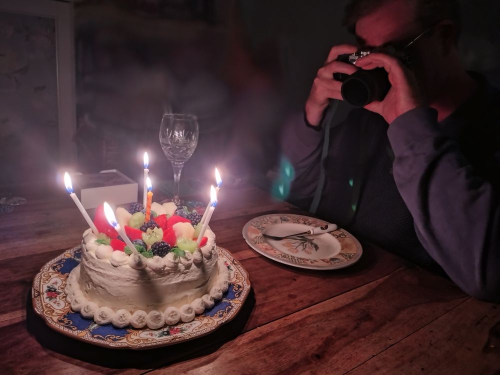 My DH holding his camera in front of his face, trying to take a picture of his birthday cake
ケーキの写真を撮ろうとカメラを顔の前に構えているダダ