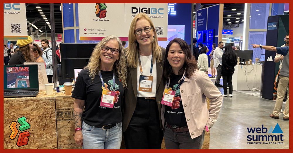 Three woman of different ethnicities pose in front of a small booth with a sign that reads, "SSG" and "DigiBC". Left to right, Tina Merry, Hon. Finance Minister Brenda Bailey, Carina Kom.