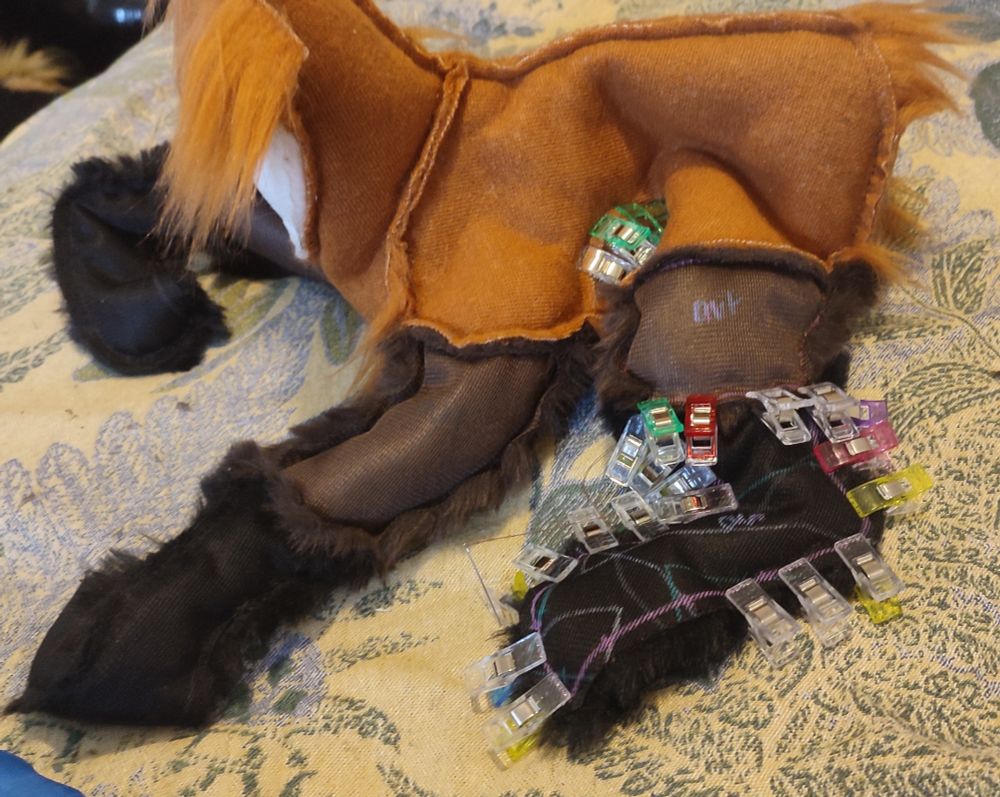 A work in progress plush. It is a quadrupedal, rusty coloured animal with long dark legs and a white throat patch.