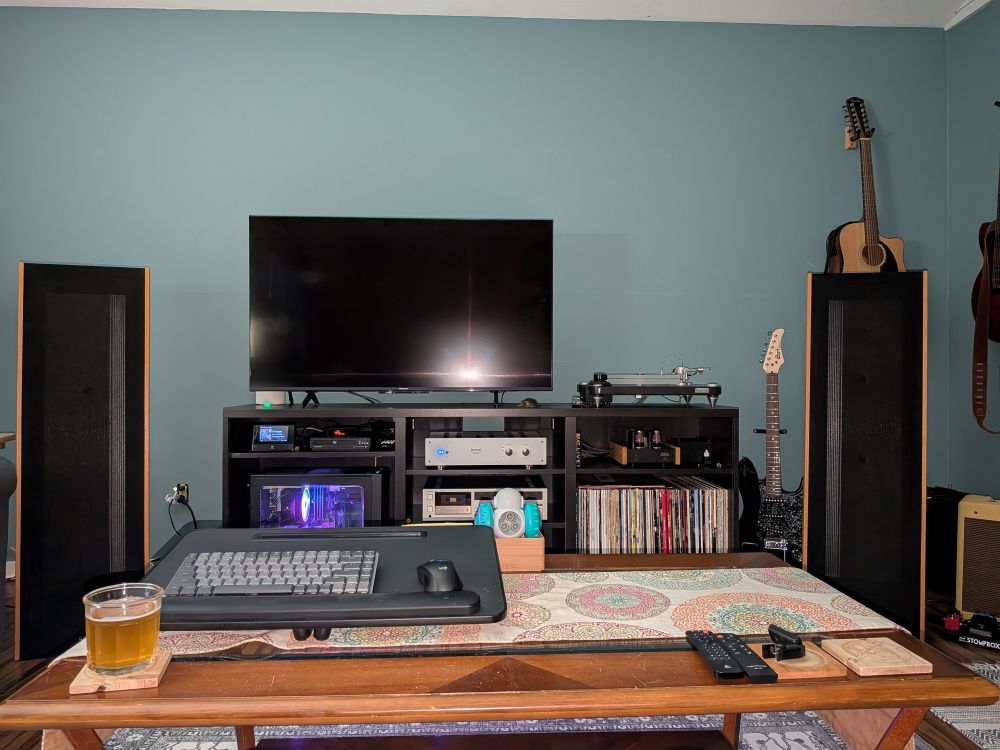 Picture of hi fi entertainment center with guitars hanging on the wall