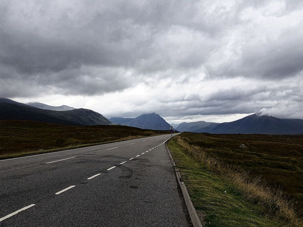 Highlands, somewhere in between. central perspective: centre strip, turf, shadows lead towards the mountains, the clouds, wherever.