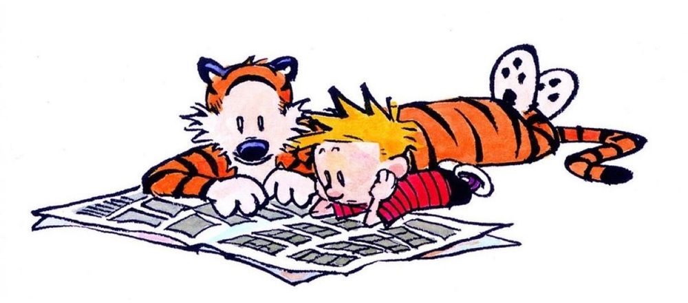 Calvin and Hobbes cartoon. The pair is lying on the floor reading a newspaper 