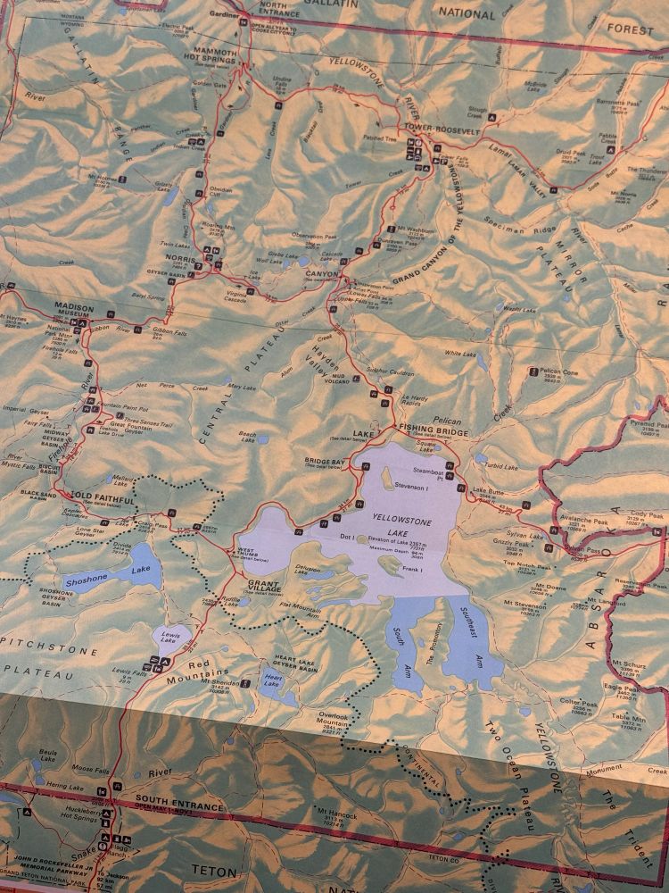 Map of Yellowstone National Park. Green is land, blue is water, red is roads. Yellowstone Lake sits near the center of the image.