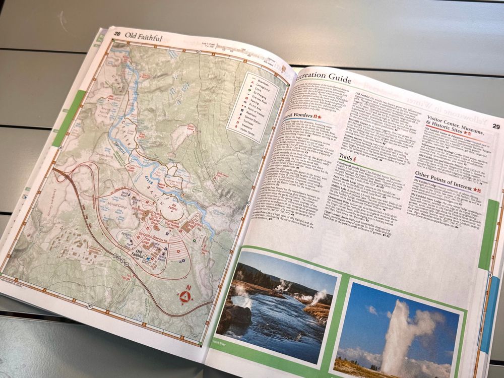 Atlas open on a table. Map of the Old Faithful area on the left, listings and photos on the right. The photos are mine.
