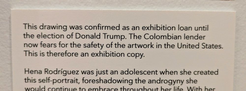 Photo of text on a sign at a museum exhibition that reads: this drawing was confirmed as an exhibition loan until the election of Donald Trump. The Colombian lender now fears for the safety of the artwork in the United States. This is therefore an exhibition copy.