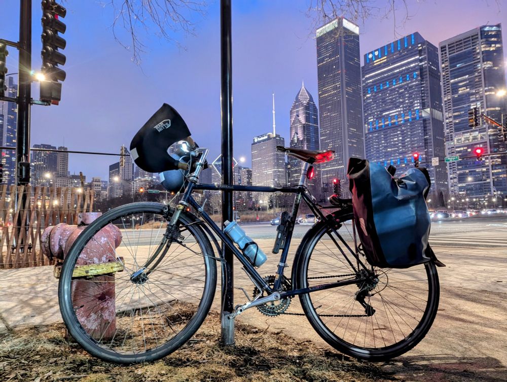 Heroic photo of a bicycle with tall buildings behind it at twilight. 