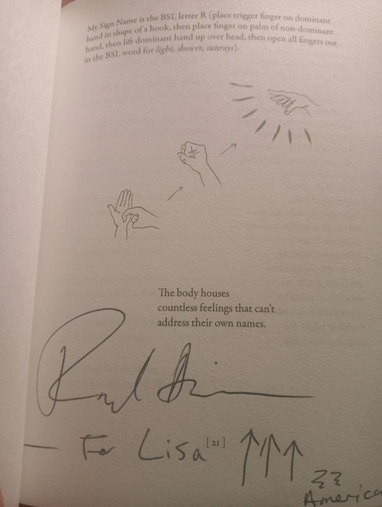 Deaf poet, Raymond Antrobus explains their sign name in BSL - an illustration is provided on the middle of the page. Text reads "My Sign Name is the BSL letter R (place trigger finger on dominant hand in shape of a hook, then place finger on palm of non-dominant hand, then lift dominant hand up over head, then open all fingers out in the BSL word for light, shower, sunrays)." This is followed by "The body houses countless feelings that can't address their own names." Towards the bottom of the page is the poet's autograph & my sign name in Raymond's notation form. 