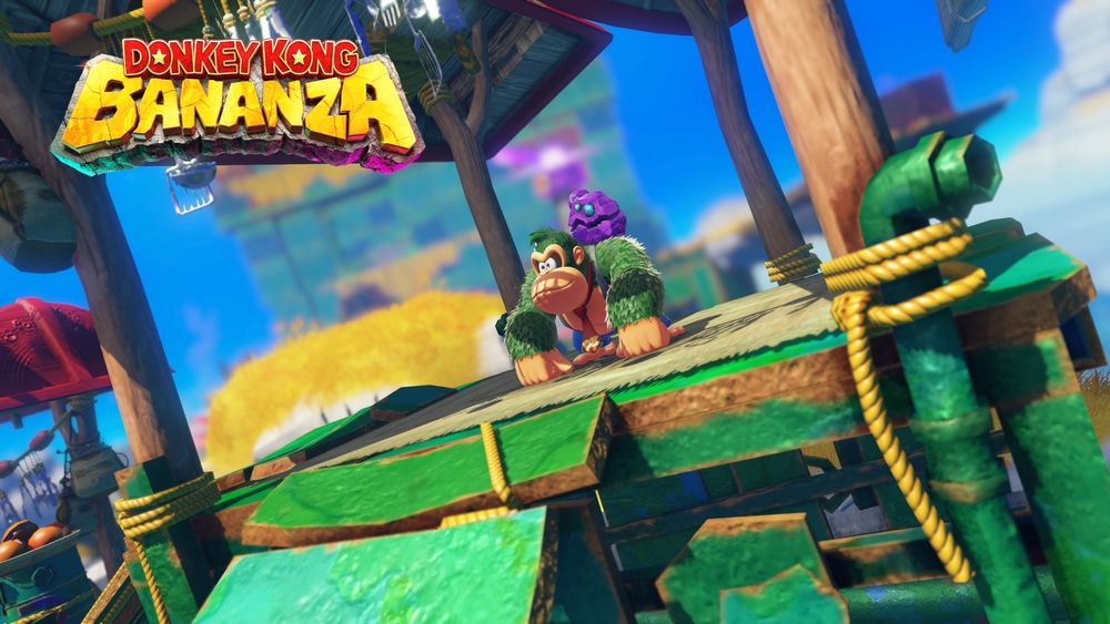 Capture d'écran du jeu Donkey Kong Banenza. On y voit Donkey Kong avec le pelage teint en vert, accompagné d'une pierre étrange sur son épaule dans un décor chatoyant et coloré. Les personnages ont une pose neutre et sont dans un genre de kiosque en bois.