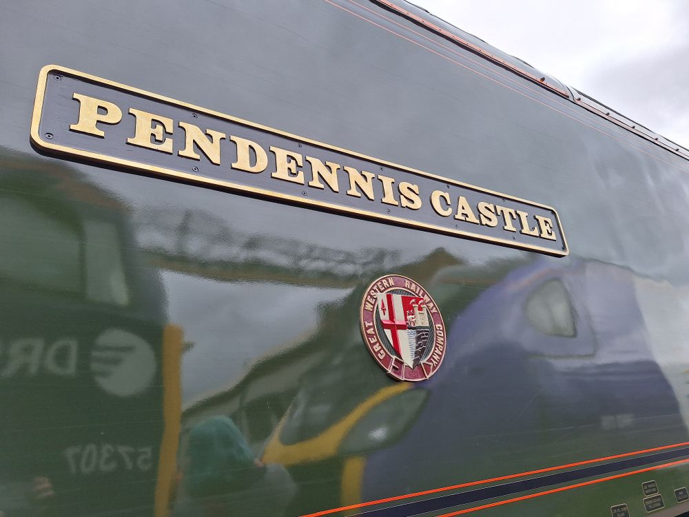 Image shows the nameplate of class 57 locomotive 57604. It reads "Pendennis Castle". Also shown is the old GWR crest.