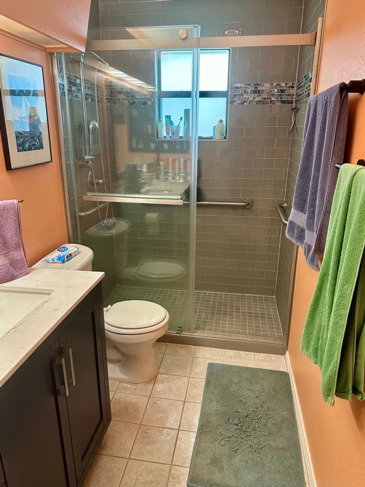 Coral and gray bathroom featuring a roll-in shower 