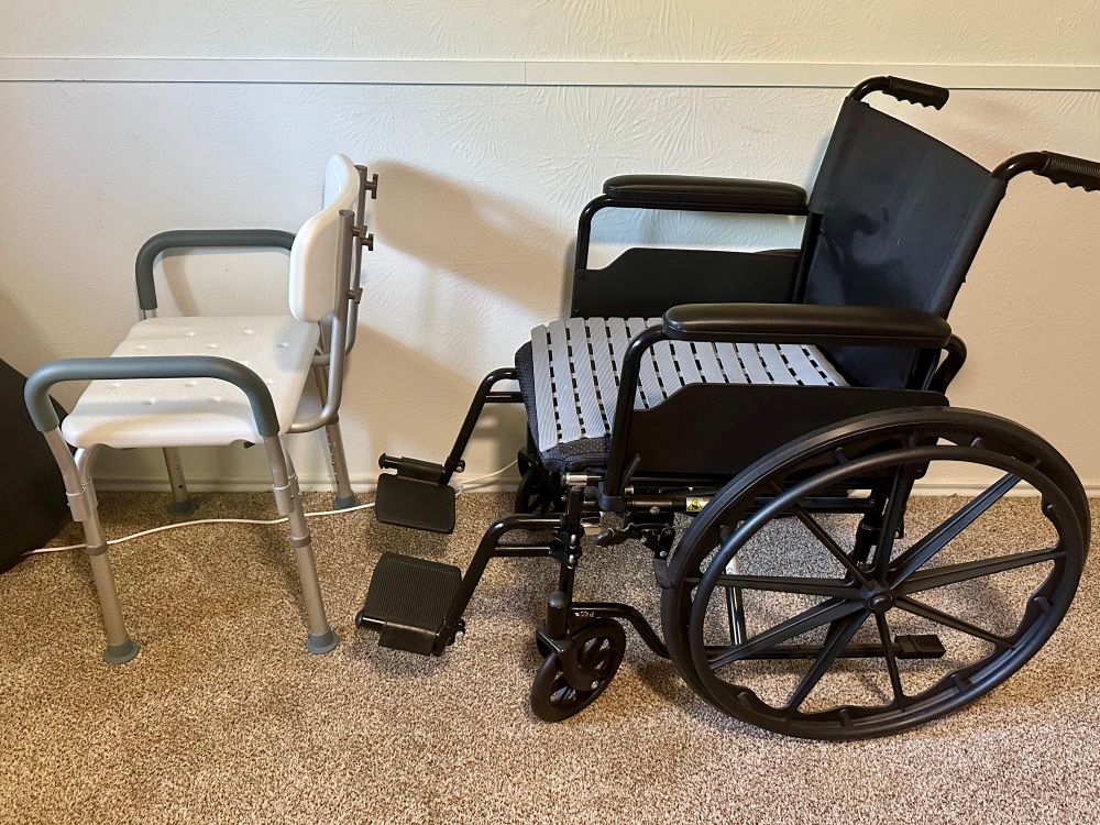Black wheelchair and white shower chair