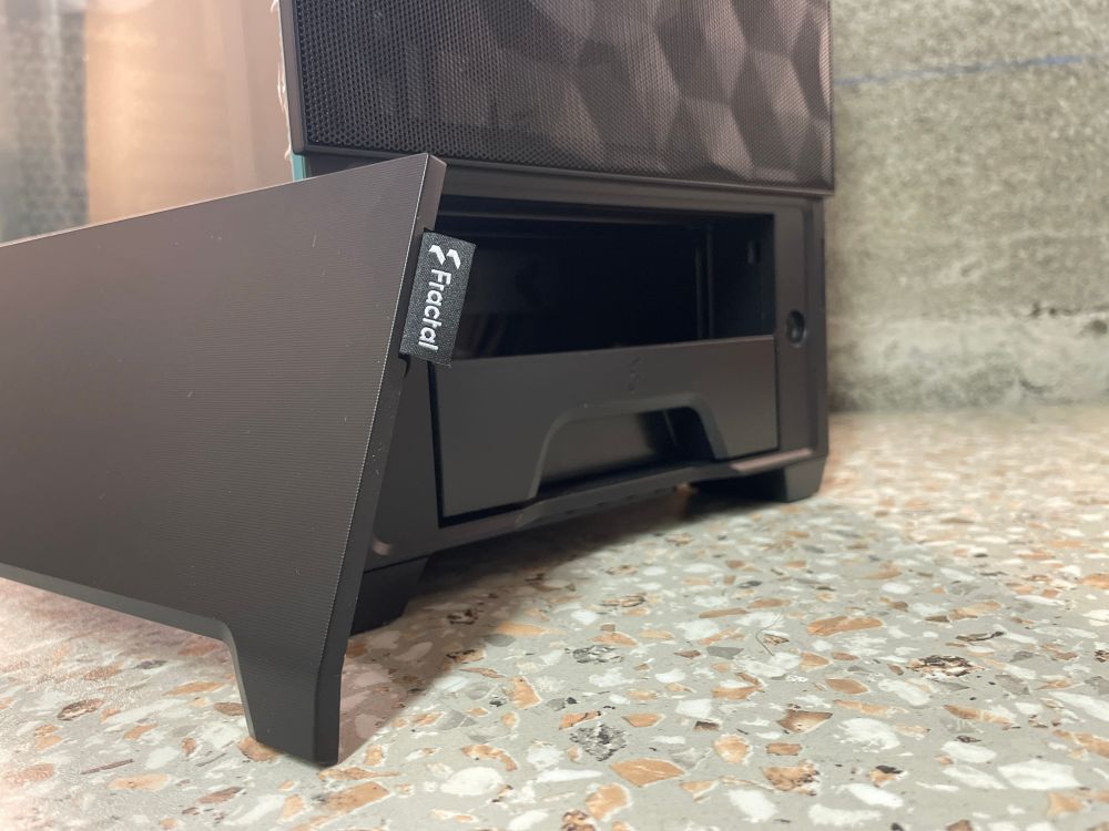 Photo du bas d’un boîtier PC Pop Fractal Design, la trappe magnétique est ouverte laissant apparaître un espace libre