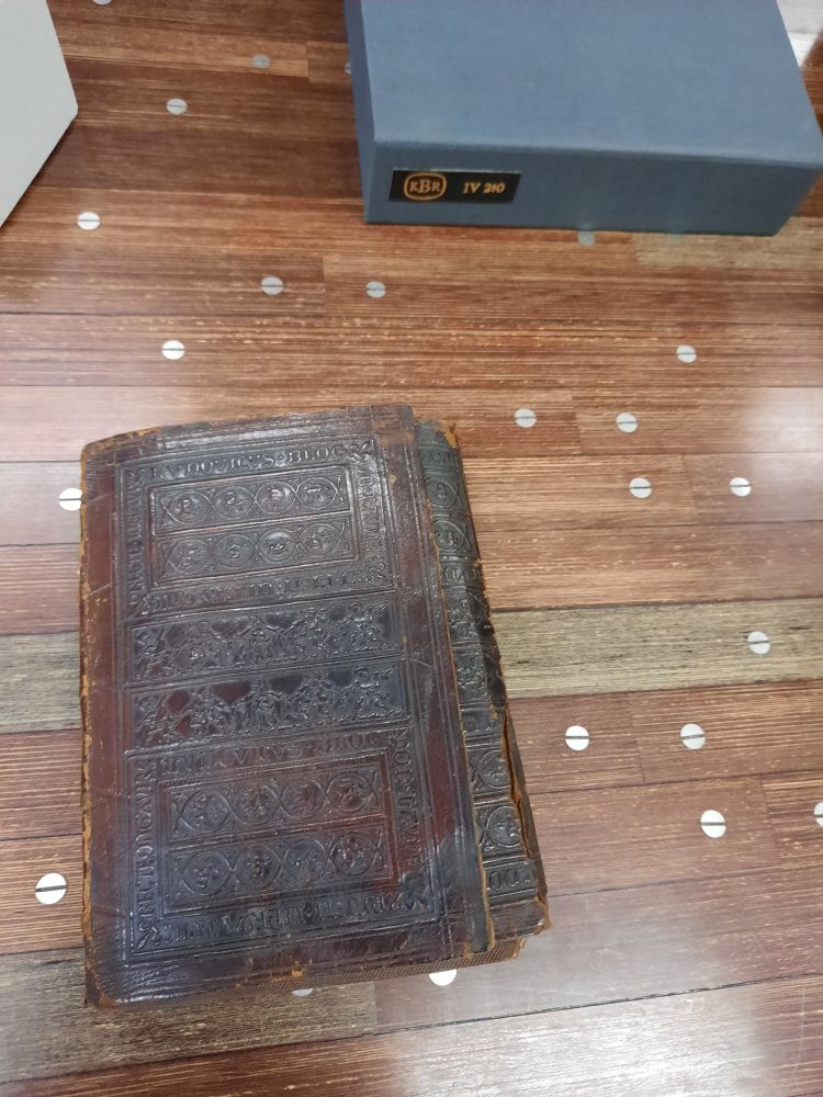 A dark brown leather binding with a flap and panel stamps with renaissance motifs. 