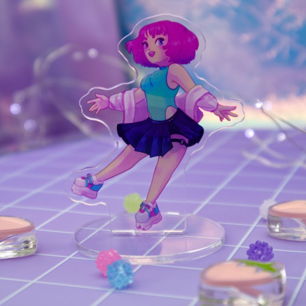 Photo of an acrylic standee of Berry, a pink-haired female character with teal jumpsuit, white jacket, black skirt, and platform shoes.  Small beads are scattered in the front of the photo.