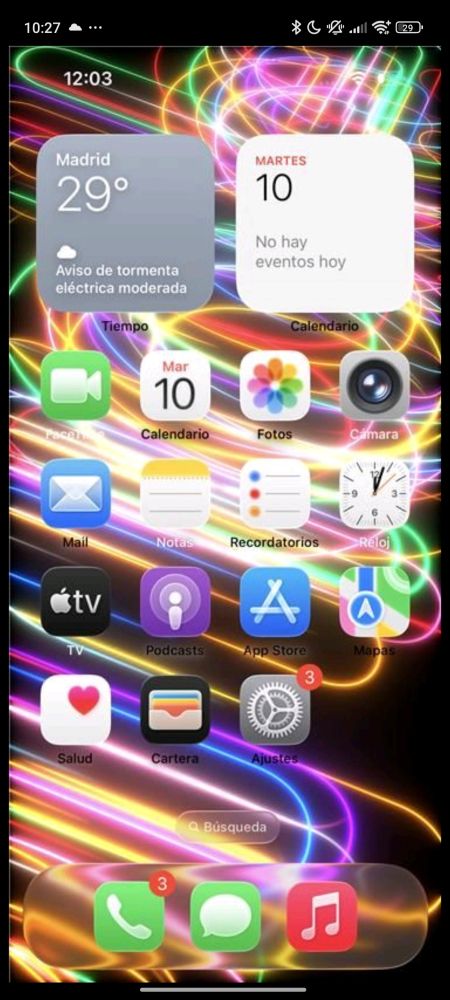 Pantallazo de iPhone en su pantalla de inicio con el nuevo estilo Liquid Glass. Los textos de las aplicaciones apenas son perceptibles. Una opción de busqueda apenas es perceptible. El borde del menú inferior apenas es perceptible.