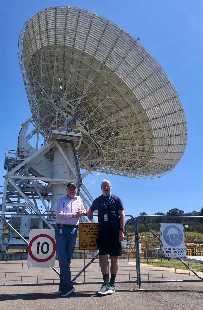 Glen Nagle (left) and myself standing at a gate. Behind us is DSS36 one of the 34m antennas in the DSN network which is pointing to the upper right.