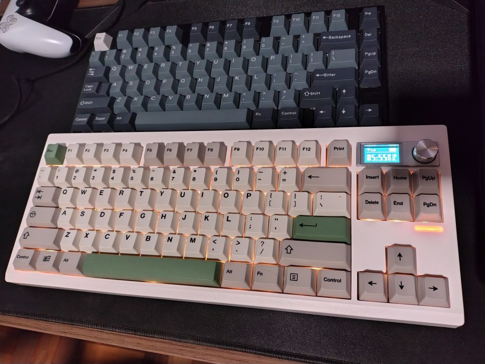 Two computer keyboards. Top: Weikav D75 black, Gateron Cap Milky Yellows V2 switches, KBDiy GMK Apollo clone keycaps / Bottom: Zuoya GMK87 white, Gateron Baby Kangaroos V2 switches, KBDiy GMK 9009 keycap clones