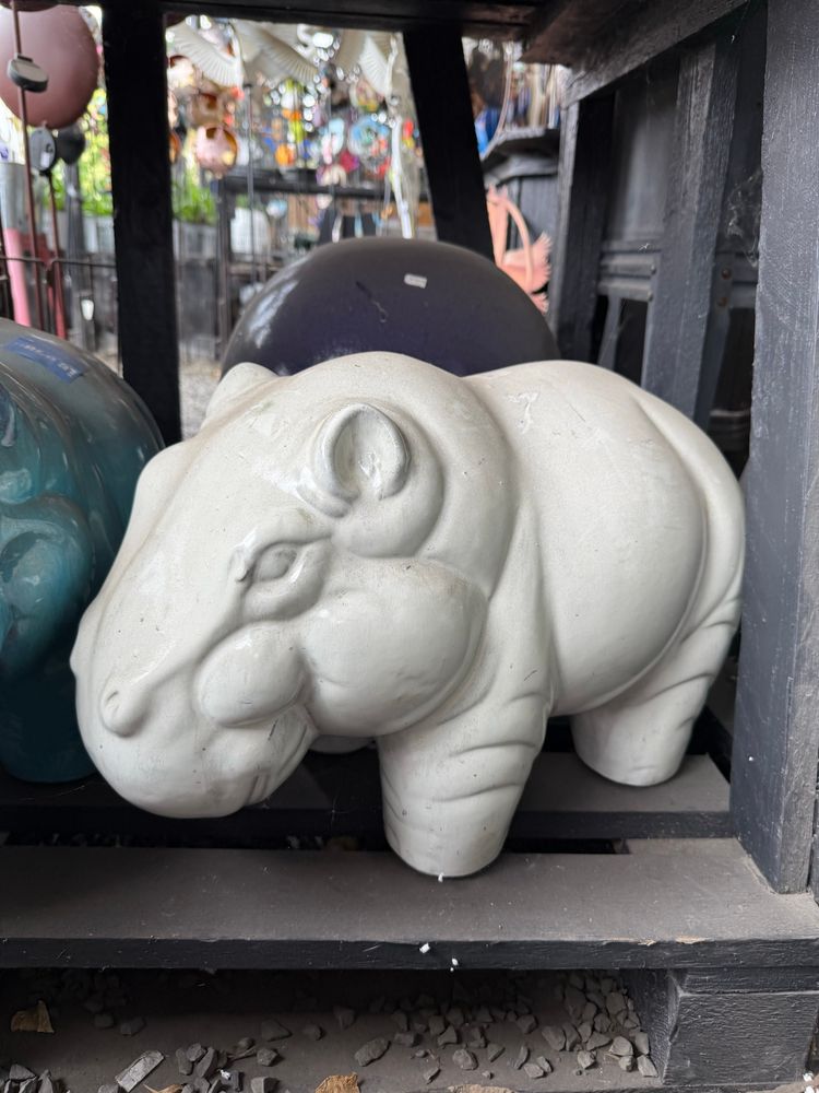 White-glazed terracotta outdoor sculpture of a hippo