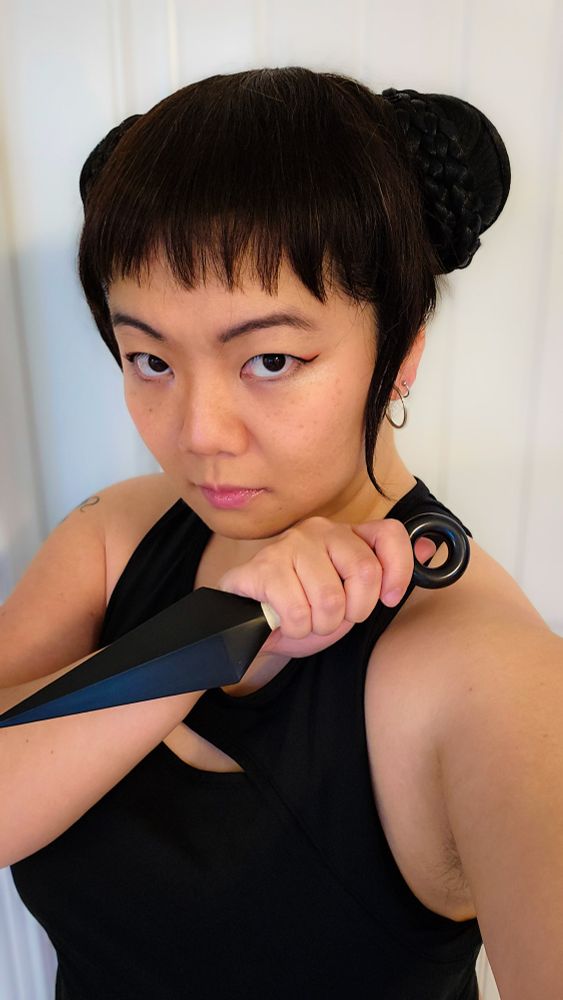 Photo of JWo cosplaying as Zoey from the movie K-Pop Demon Hunters holding a kunai blade
