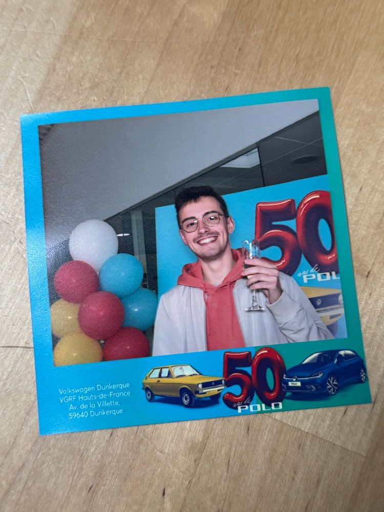 Photo de Loïc tenant une flûte de champagne dans une concession Volkswagen à l’occasion d’une soirée anniversaire 