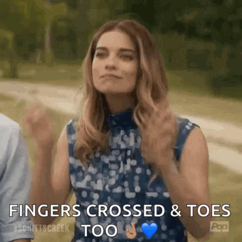 a woman says fingers crossed and toes too in a gif