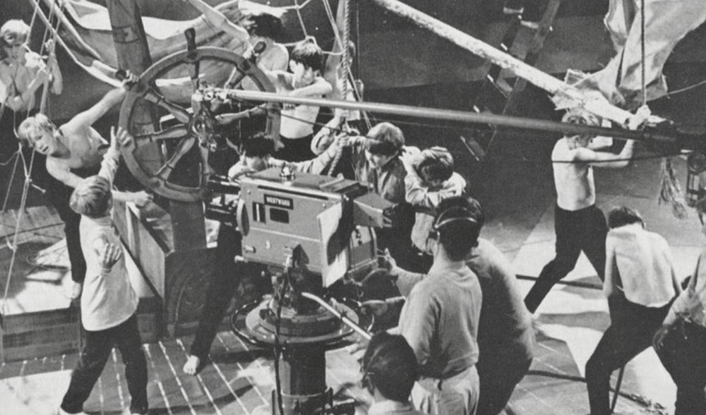 Playbill. Boys act out a scene set on the deck of a sailing ship while a Westward studio camera watches.