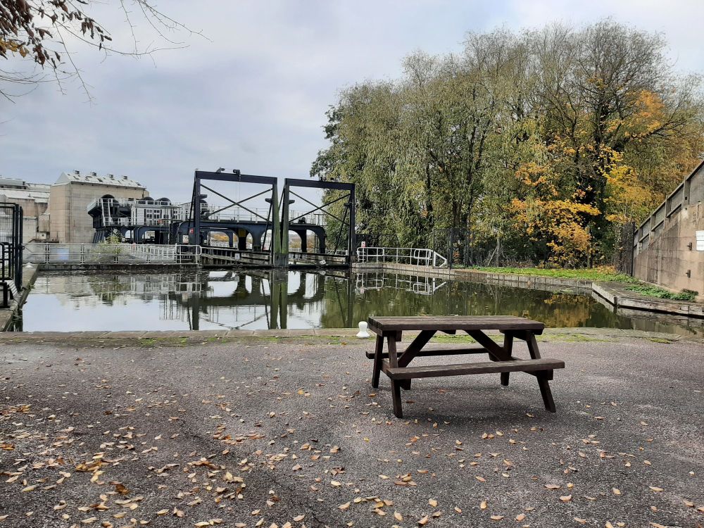 The top of Anderton Boat Lift, with factories in the background and a picnic table in the foreground.