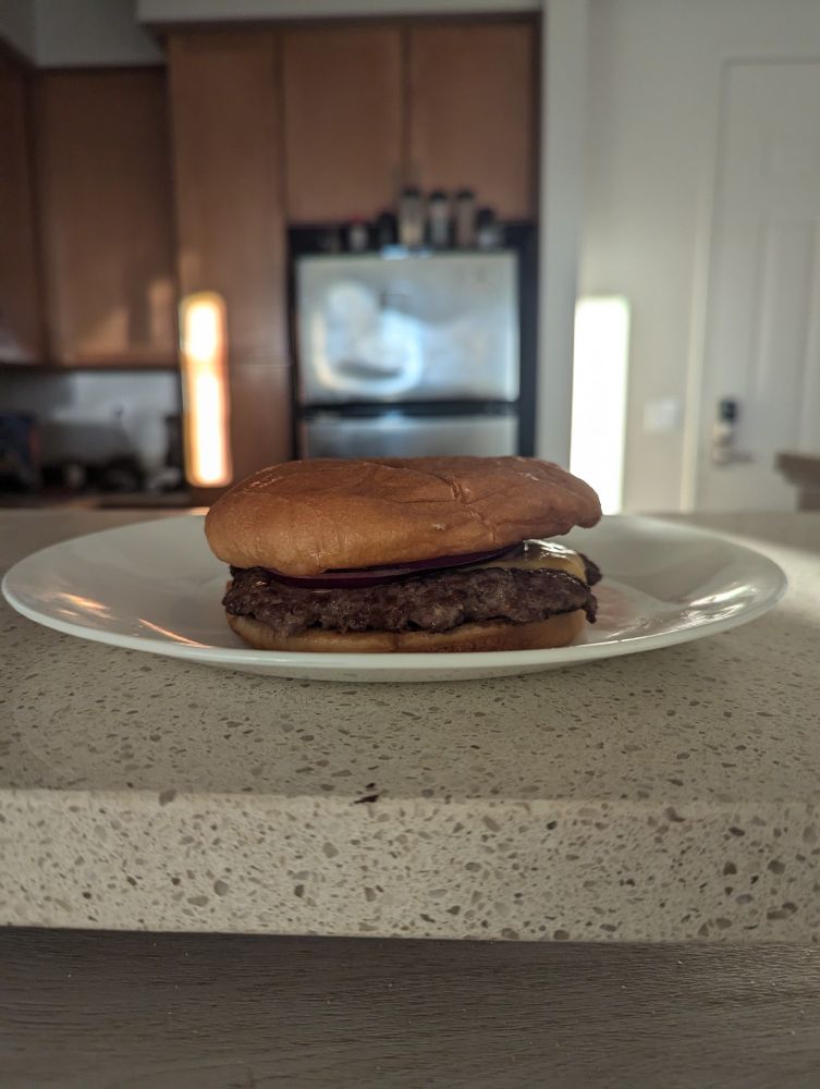 hamburger with cheese, pickles, onions, and barbeque sauce