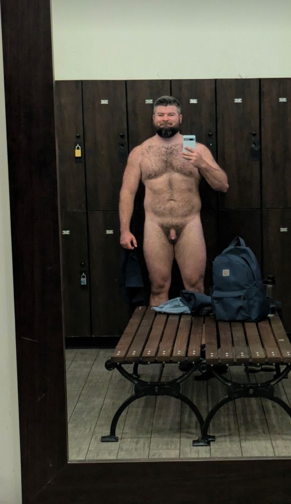Handsome bearded man embodying masculine beautiful. Completely naked soft and proud covered in hair casually naked in the locker room. 