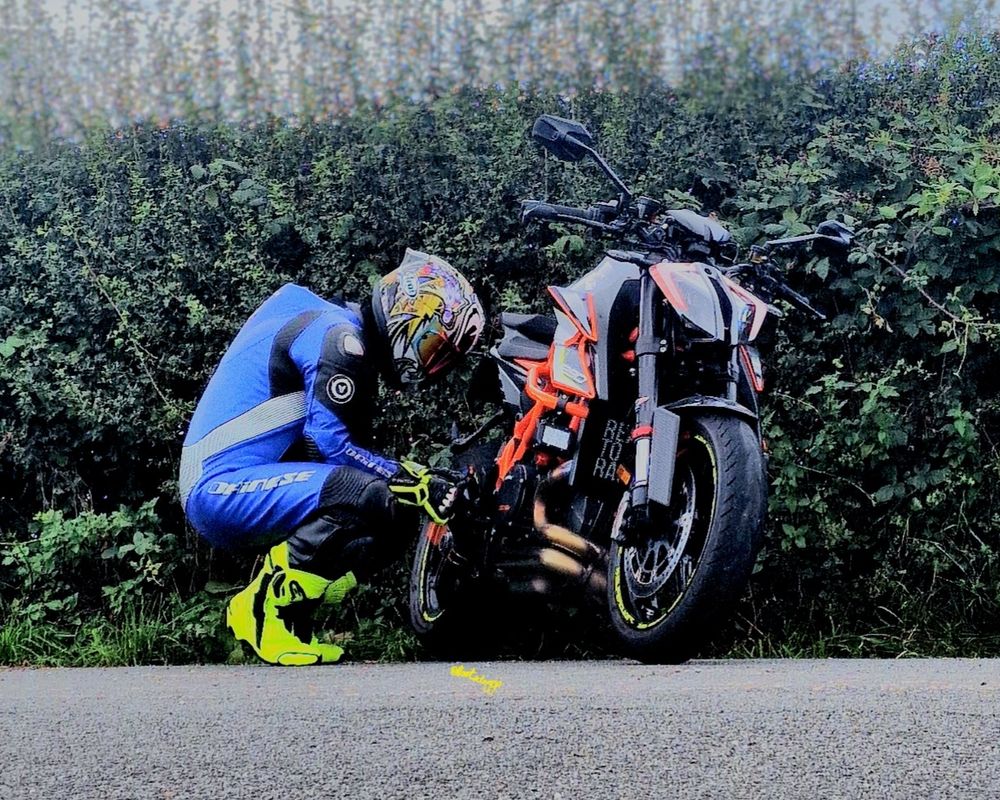 Biker crouching beside his bike