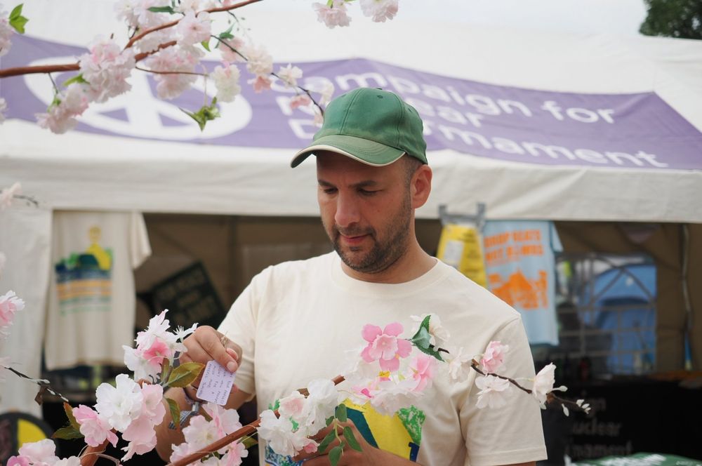 Zack writing a message on the Hiroshima Tree outside the Campaign For Nuclear Disarmament 