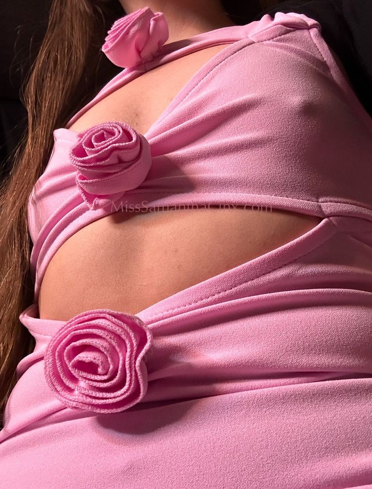 Miss Samantha Cinx findomme Goddess wearing one of Her favorite sub funded dresses, a pink mini dress with cut outs revealing Her firm flat tummy and in between Her perky tiny tits, decorated with fabric roses around each cutout. Her perfect pointy nipples poke through the thin pink fabric covering Her small breasts. Her golden honey-like hair cascades down Her shoulder and past Her hip. FLR. femdom. goddess worship. 