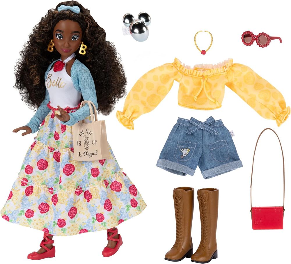 The new deluxe Disney ILY 4Ever Belle doll. She has dark skin, grey eyes and brown curly hair with her hairline pulled back and pinned with a light blue bow. She wears gold earrings shaped like the letter B and carries a taupe tote bag. She has a thin light blue bolero cardigan and a white halter-neck tank with the name Belle on it in gold. Her maxi-skirt features red roses plus yellow and blue flowers and is topped with a thin red plastic belt. Her shoes are flat pumps with crossing ribbons reaching up her calves. Her second outfit is a yellow off-shoulder drawstring blouse with blue denim shorts and brown lace-up boots. She also comes with a simple red rectangular bag with a gold strap, a gold necklace with red charm, and red sunglasses with daisy-shaped lenses