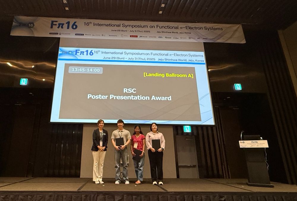 Three poster prize winners on stage with certificates alongside the presenter, the slide behind displays RSC Poster Presentation Award